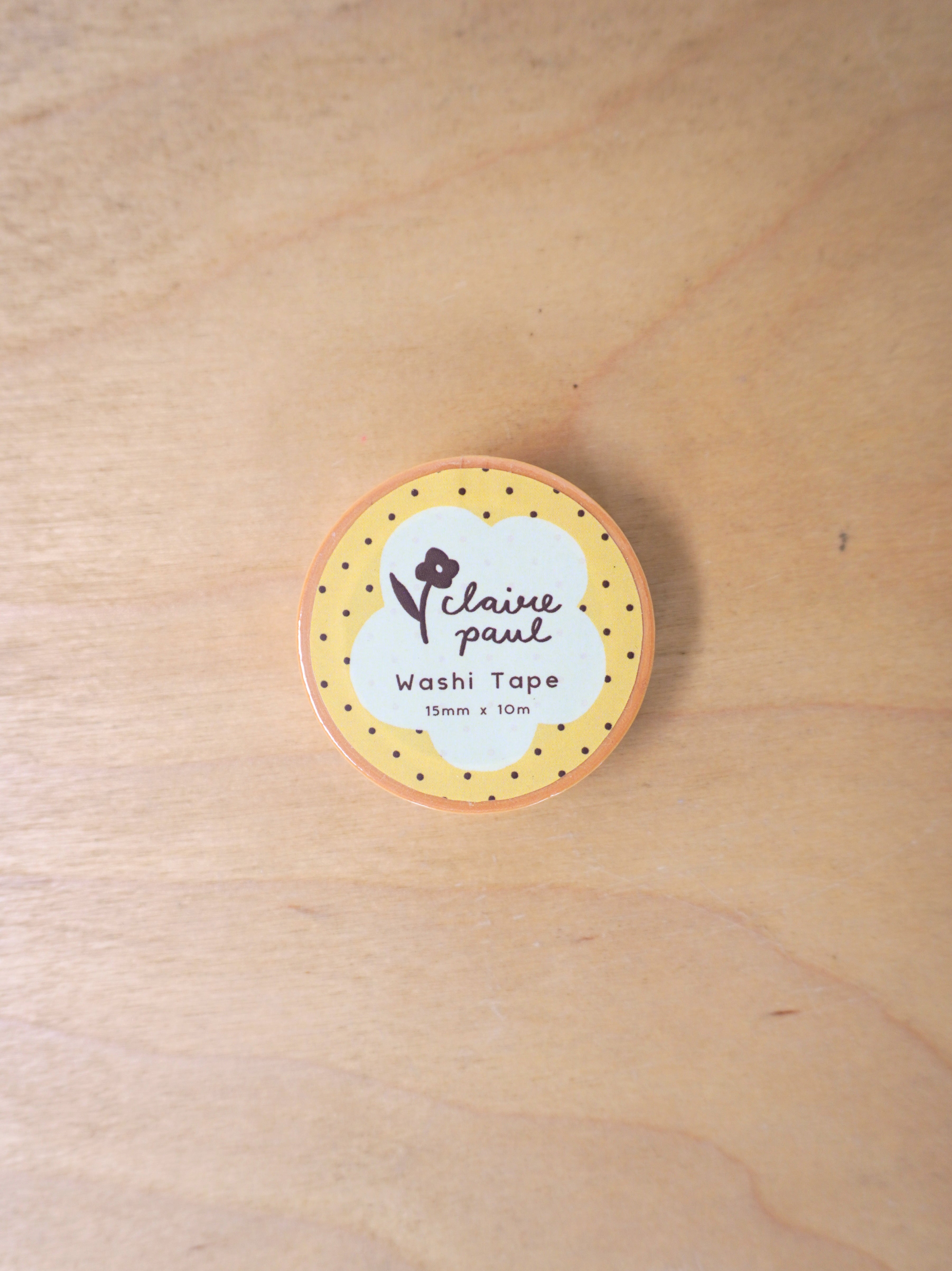 Round washi tape roll with a label on a wooden surface
