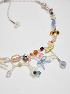 Colorful beaded necklace with various charms on a white background