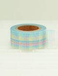 A roll of pastel plaid washi tape with light blue, pink, and yellow stripes, displayed on a clean white surface with a soft reflection.