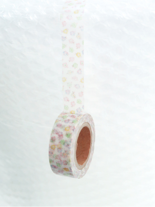 A roll of washi tape with a delicate pastel floral pattern, shown hanging against a textured white background.
