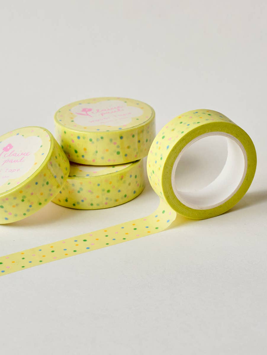 Four rolls of yellow washi tape with a pattern on a light gray background